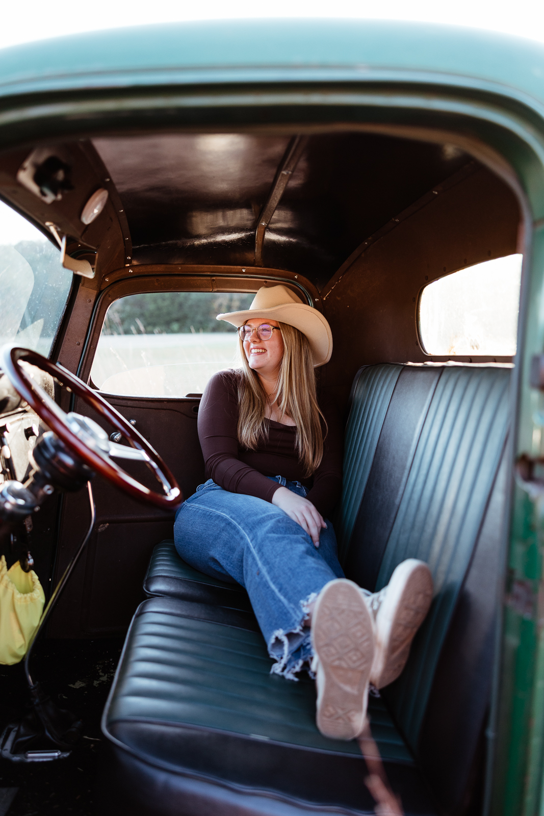 Senior girl sitting in grandpas old truck